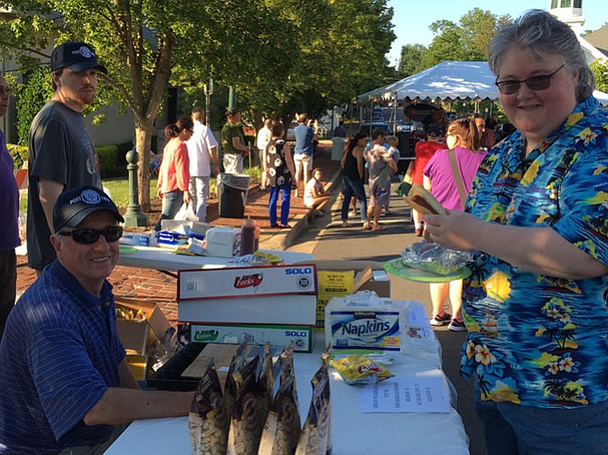 Joanie Dempsey, president of the Vienna Volunteer Fire Department Auxiliary, supports another volunteer organization in Vienna, Sons of the American Legion Squadron 180. Dempsey bought a hot dog and beans from the Sons’ booth.
