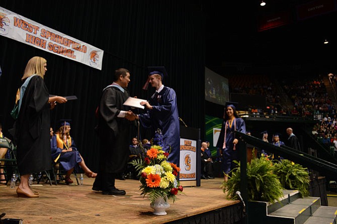 West Springfield High School principal Mike Mukai (center) hands out diplomas during the June 17 commencement ceremony at George Mason University’s Eagle Bank Arena.