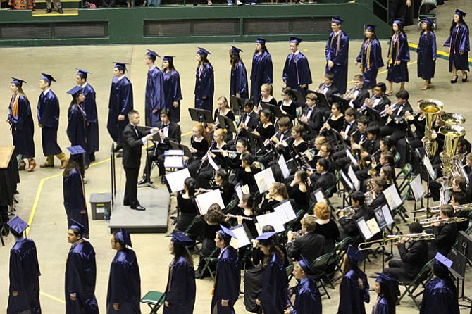 Graduates in procession past the W.T. Woodson Band conducted by Brett Dodson.
