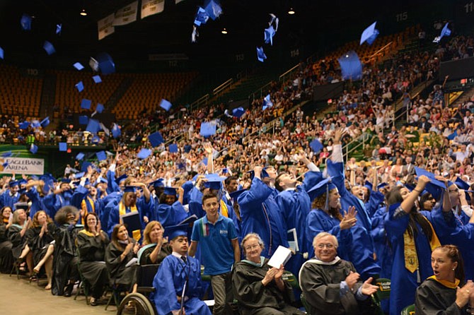 West Potomac High School class of 2016 graduates celebrate the turning of their tassels by hurling their mortarboards in the air.