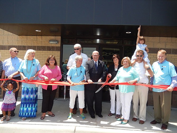 Cutting the ribbon on the new Lamb Center are (front row, from left) Richard Dwyer, Carole Waring, Ellie Schmidt, Mary Petersen, Gerry Connolly, Sharon Bulova, Janice Miller, Chap Petersen (with daughter Ida) and David Meyer. In back is John MacPherson.
