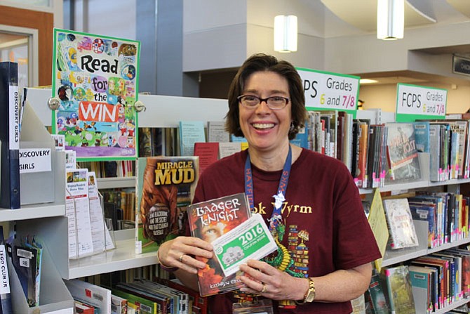 Beth Lee, Richard Byrd Youth Services librarian with the 2016 Summer Reading Challenge Coupon Book and “Badger Knight” by Kathryn Erskine, a book Lee highly recommends.
