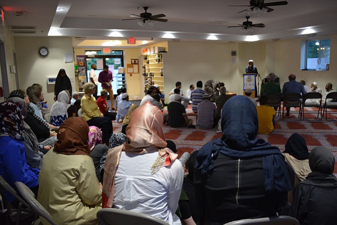 Members of the ICNA VA Islamic Center and additional community members listening to the mosque president, Rameez Abid, give a talk prior to iftar. 
