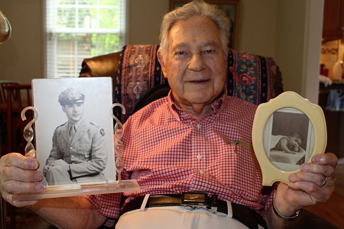 Robert Hemm, 95, holding his military portrait and baby picture.
