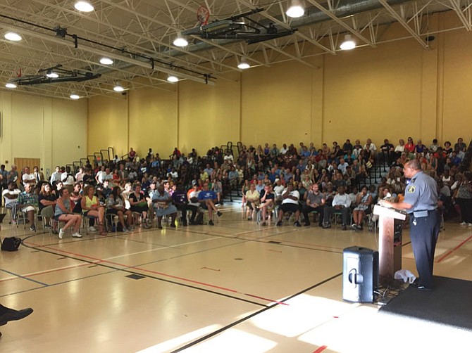 Police Chief Earl Cook discusses the Saquan Hall murder with the local residents in the Charles Houston Recreation Center .
