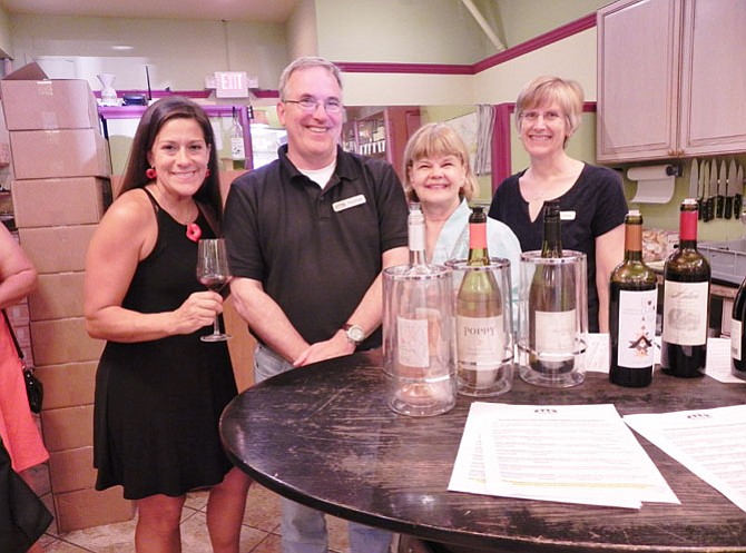 The chairman and co-chairman of the McLean Woman’s Club’s Holiday Homes tour pose with the  owners of Chain Bridge Cellars. From left: Michelle Arcari, co-chairman of the tour; Doug House, co-owner of Chain Bridge Cellars; Kathryn Mackensen, chairman of the tour; and Meg House, co-owner of Chain Bridge Cellars. 
