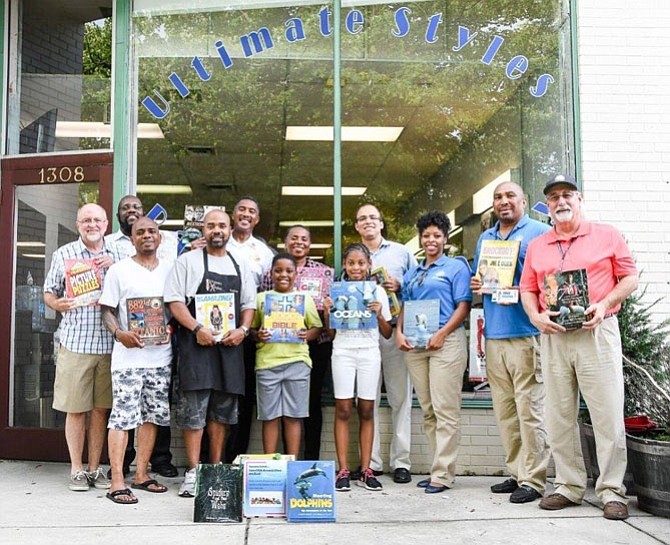 Ultimate Styles Barbershop on Mt. Vernon Avenue is one of 15 participating locations in the new Beauticians, Barbers and Books literacy initiative. Kicking off the program July 5 are from left: John Porter, Councilman John Chapman, Bennie Evans, Kariem Perry, Councilman Will Bailey, Alexandria Library Director Rose Dawson, Vice Mayor Justin Wilson, Lucresha Murphy, Michael Johnson and Mac Slover.
