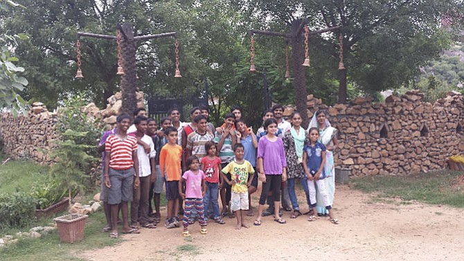 The Sarans make an annual visit to Bal Ashram orphanage in India, bringing funds and social engagement. Medhnaa is in lavender and Kushaan in orange.
