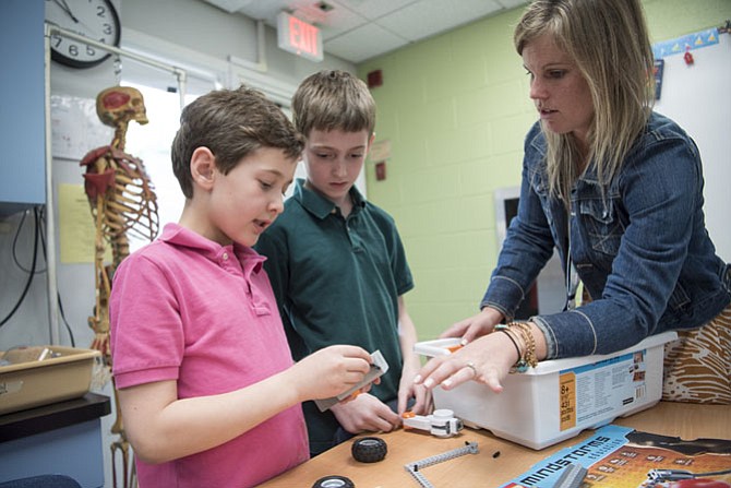 Science teacher Sarah Boor works with students at Norwood School. Educators say now is the time to prepare children for a return to school. 
