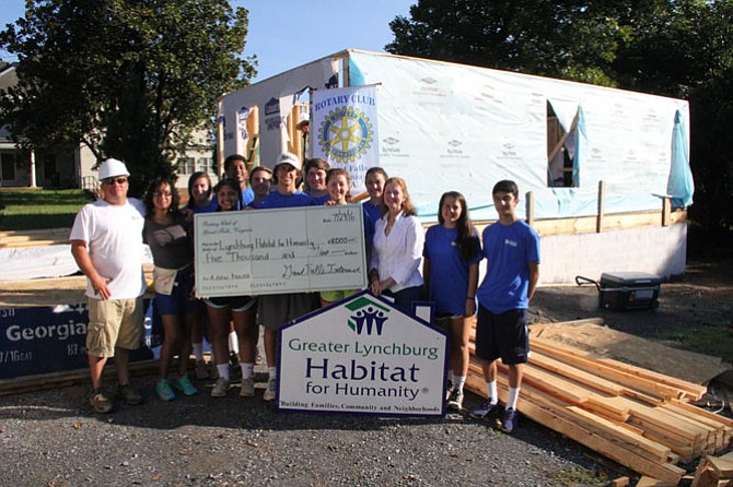Great Falls Interact Group presents donation to Lynchburg Habitat for Humanity after working on-site for summer service project. Pictured, from left, Project Foreman Joey Monile, future homeowner Lakena Scott, Katherine Joostema, Ashley Baradari, Jared Tewodros, Mark Wilson, Declan Thinnes, Hayden Owens, Thompson Brownlee, Chloe Bennett, Lynchburg Habitat Executive Director Donna Vincent, Allie Lailas, Gabe Achi
