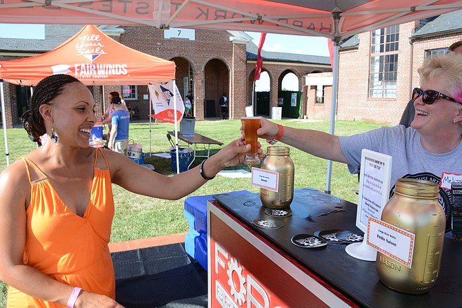 Melissa Morgan of Fairfax, right with Forge Brew Works in Lorton serves Shamara Wilkins of Lorton, left, a cold brew at the Workhouse Arts Center Brewfest on Aug. 13.