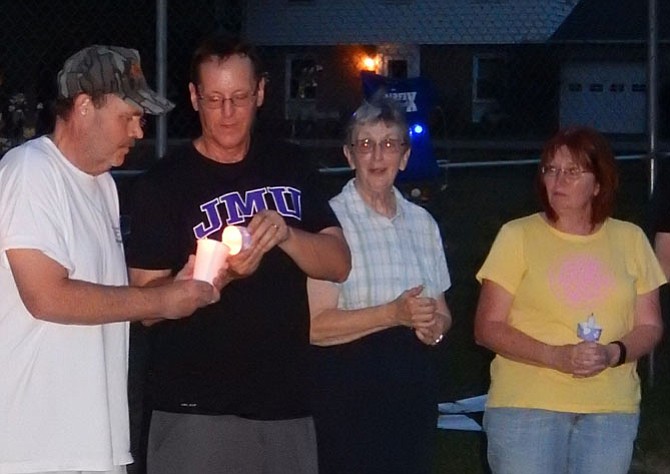 Lighting their candles are from left Jay Quade, Carey Cole, Pat Skeins and her daughter-in-law Debbie Skeins at the vigil. 
