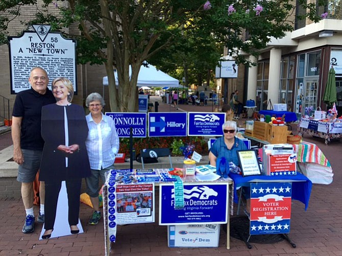 Hillary Clinton look alike visited the Democratic Party table at the Reston Farmers Market last Saturday morning. The Dems have been a presence at the Market nearly every Saturday for a dozen years. From left -- volunteers Roger and Carrie Bruns with Ms. Clinton, Ann Cosgrove seated at table.
