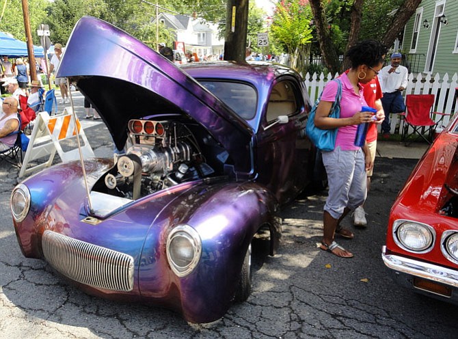 Attendees peruse some of the cars at a previous show.
