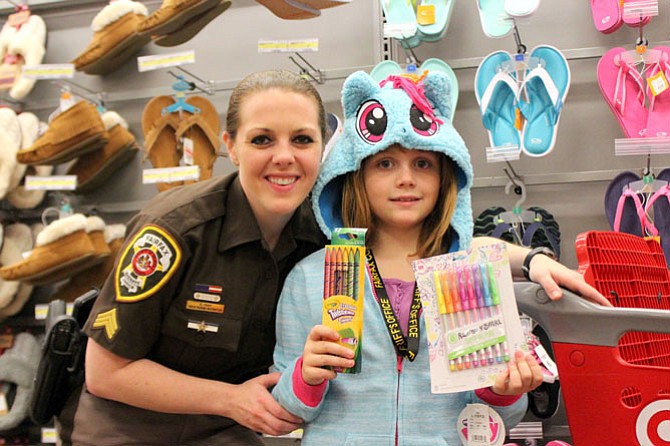 Sargent Emily Fary and Lily, 8, posing with the My Little Pony coat and the gel pens to replace the ones she missed having.
