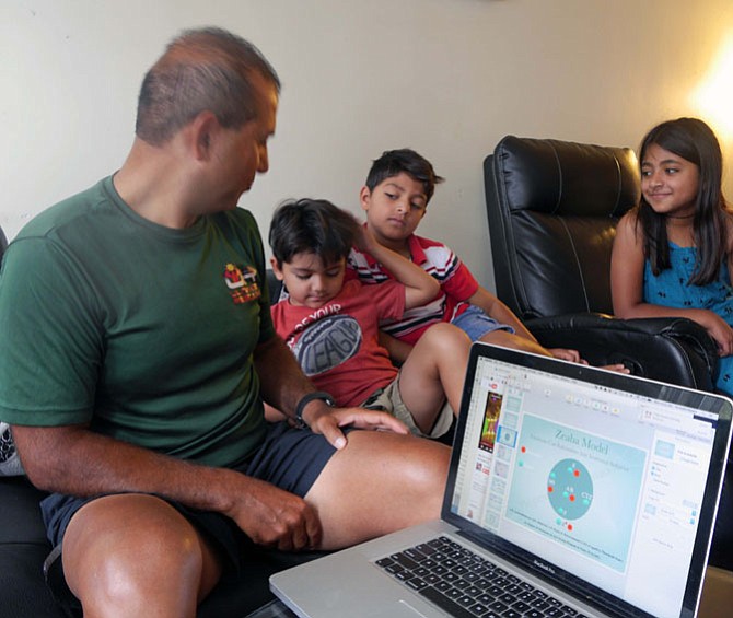 Mustafa Nazary, surrounded by three of his children, illustrates his behavioral model, Zeaba, named after his mom and his oldest daughter (right on couch.)
