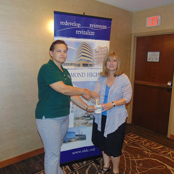 Following Anna Urman's presentation, SFDC Executive Director Edythe Kelleher presents a commemorative SFDC coffee cup.