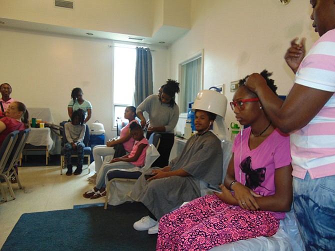 Volunteers cut and style students’ hair.
