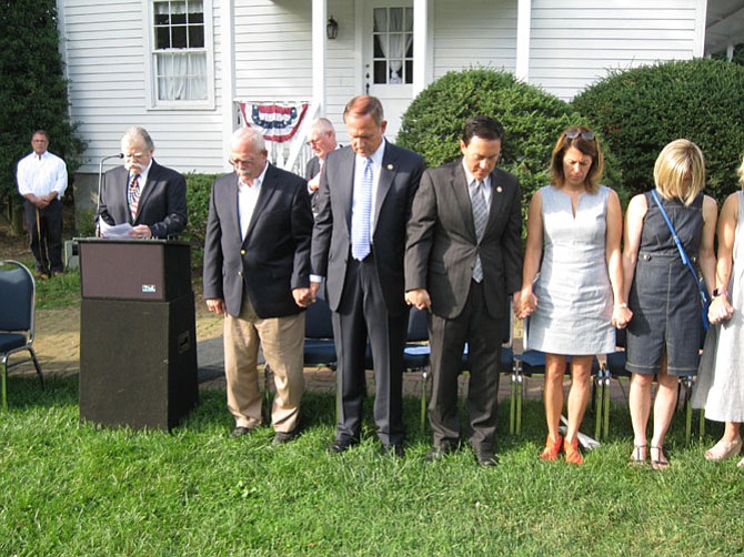 Guests hold hands while the Rev. John Giunta gives the Invocation.