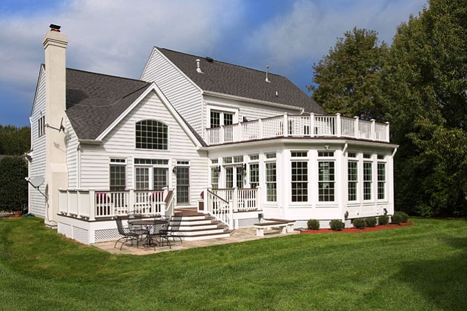 Duotone slats installed in alternating diagonal and parallel lines lend visual interest to the new deck. The flagstone patio, likewise, employs contrasting colors and shades.
