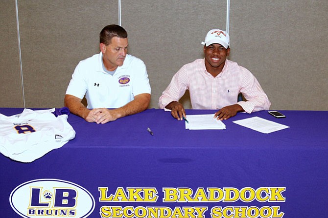 Lamont Atkins, of Burke,  signed his grant-in-aid scholarship package to play football for the University of Virginia. He is joined by his coach Jim Poythress, Lake Braddock’s Varsity Football Head Coach.
