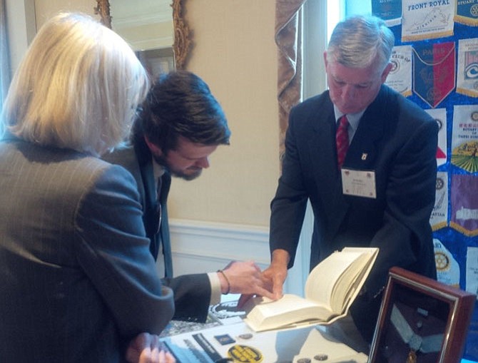 Kevin Rue, right, looks up information on the grandfather of Casey Lindsey, left, who was a POW during the Vietnam War as Julie Clifford looks on. Rue, a retired Army colonel and member of the Friends of Rocky Versace, gave a presentation to the Alexandria Rotary Club Sept. 13 honoring local POWs and those still missing in action in advance of POW/MIA Recognition Day Sept. 16.