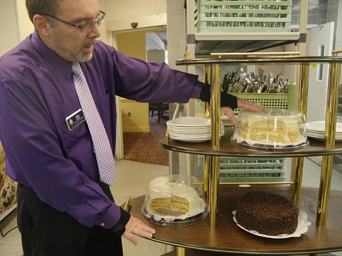 Mike Solari, the purchasing and catering manager at Vinson Hall, readies the dessert cart for lunch with coconut cake, chocolate mousse and lemon cakes. Soon it will be full of tarts and other choices offered in the formal dining room.
