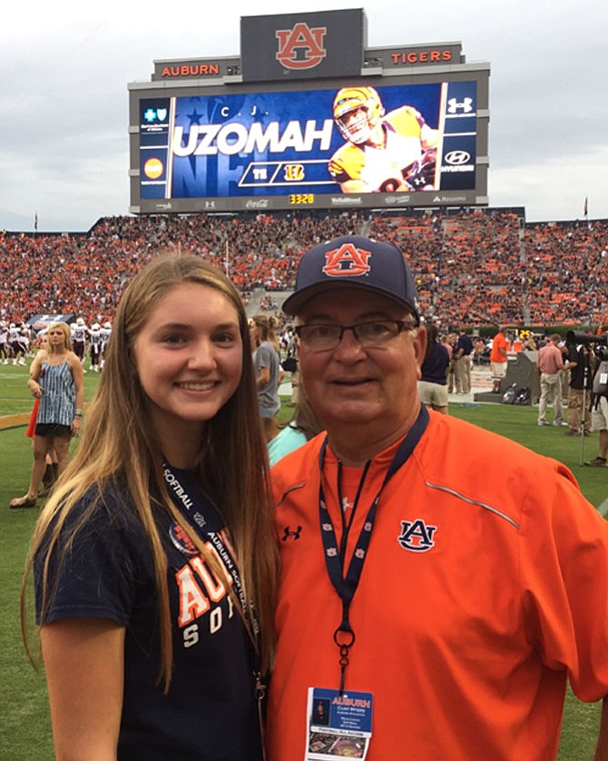 West Potomac High School freshman Claire Davidson (left) and Auburn University softball head coach Clint Myers (right) attend a recent Auburn football game.