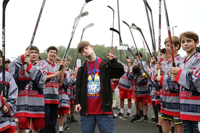 Tanner Kerby, 17, from Warrenton stands with members of Potomac Patriots Hockey after receiving a medal from them upon completion of the Buddy Walk.
