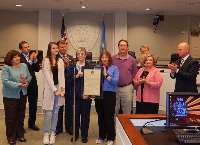 Presenting the resolution to Harold Skeins’s family, (front row, from left) granddaughter Haley Skeins; wife Patricia Skeins; and daughter and son-in-law, Becky and Carey Cole, are (back row, from left) Council members Ellie Schmidt, Jon Stehle, Jeff Greenfield, David Meyer and Janice Miller; and Mayor Steve Stombres.
