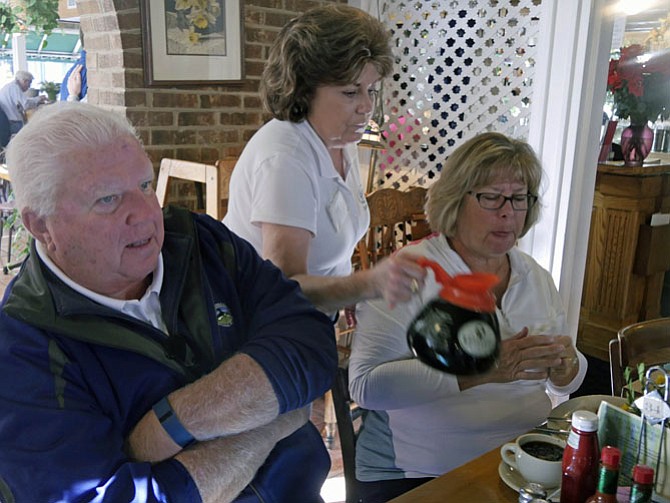 Gloria Connor, waitress at Table Talk Restaurant on Duke Street, fills up a cup of coffee as she chats with customers. One couple has returned from Arizona for a visit and is having breakfast with friends. They used to live just down the street at Carlyle Towers and wanted to return to a favorite spot.