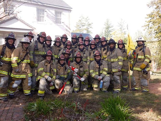 Recruit Class 73 poses after fighting the “fire” holding their recruit class flag.
