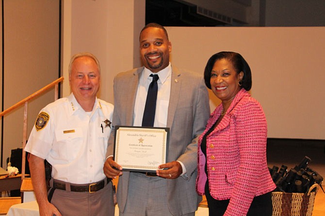 Kristopher Futrell (center) receives a certificate of appreciation from Sheriff Dana Lawhorne (left) and Lavern Chatman.