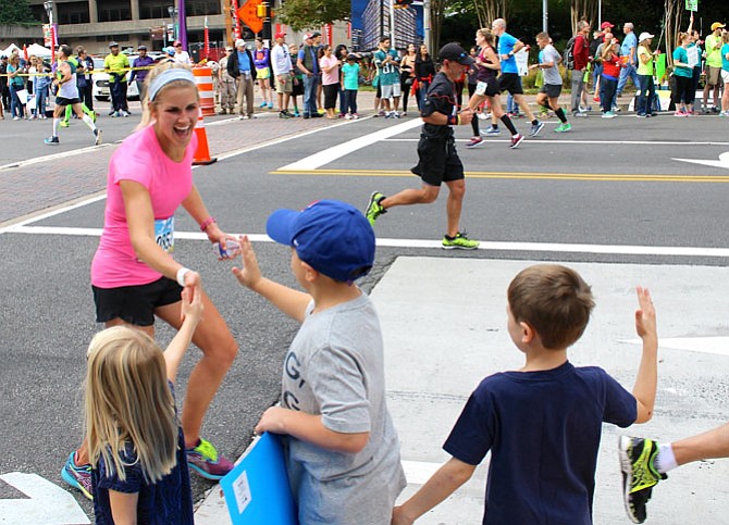 Cara Donley gets high-fives from her niece and nephews as she runs through Crystal City during the Marine Corps Marathon Oct. 30. Donley, 26, completed the 26.2-mile course in 3:26:16, placing 70th among all female runners.