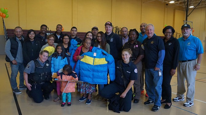 Volunteers from Alexandria’s police, fire, sheriff’s and recreation departments gather Oct. 29 during the annual Firefighters and Friends coat distribution day at the Charles Houston Recreation Center. More than 300 adult and children’s coats were given to families from across the city.