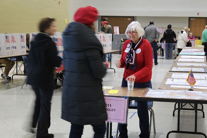 Election Official Mary Satian, a volunteer, helps voters get in line for the correct precinct at Langley High School.
