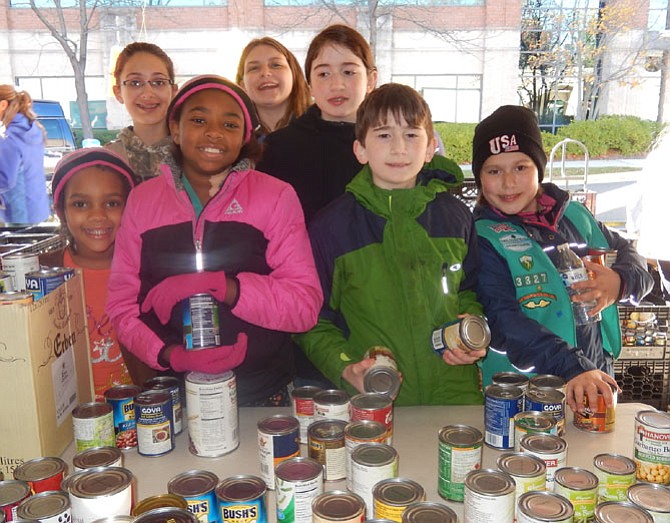 Sorting canned goods last year are members of Girl Scout Troop 3327 of West Ox Baptist Church in Chantilly.
