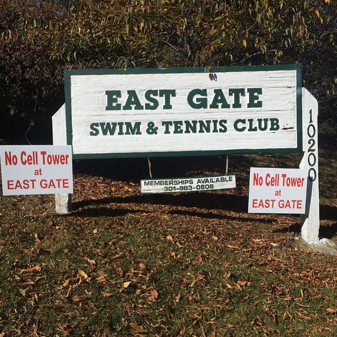 Protest signs are affixed to the East Gate Swim and Tennis Club sign.