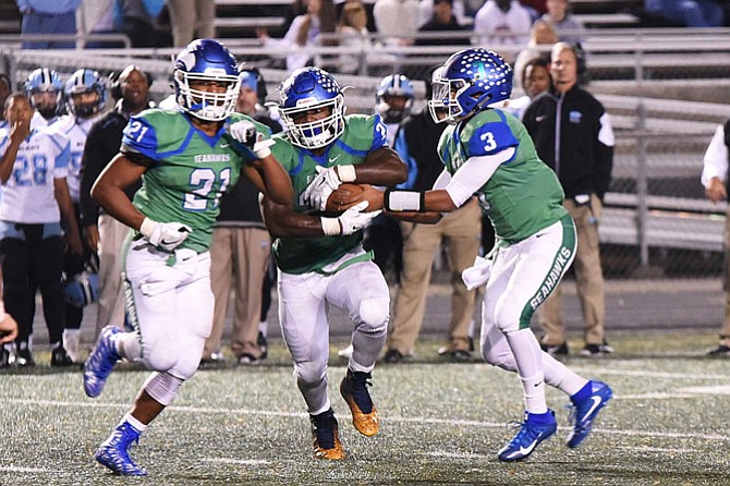 Albert Mensah with ball, quarterback Devin Miles, and Spencer Alston.
