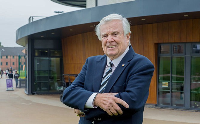 Alexandria resident Sir Stuart Matthews stands in front of a new building on the campus of England’s University of Hertfordshire that has been named in his honor. Matthews, a longtime resident of Alexandria, is a graduate of the university.