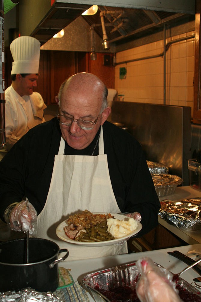 Bishop Paul S. Loverde serving at last year’s Thanksgiving dinner at Christ House.