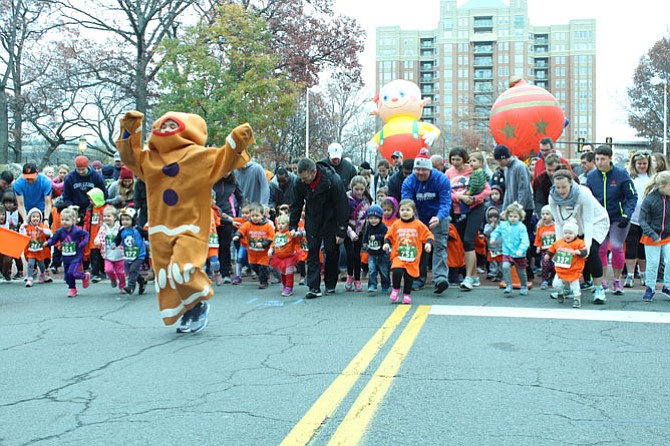 The tot trotters, children aged 3 and under, chase after the gingerbread man as parade balloons are inflated in the background.
