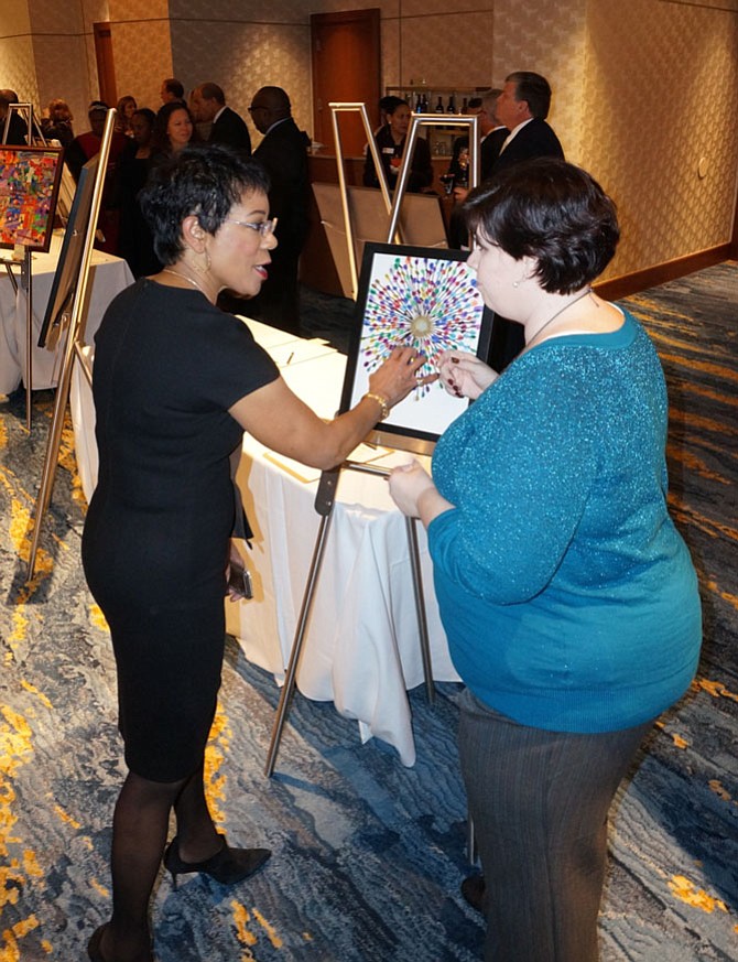 Helen Day preschool principal Dawn Erausquin, right, shows off the artwork of her students to WUSA9 news anchor Andrea Roane during the Hopkins House Preschool Scholarship Gala silent auction Nov. 17.
