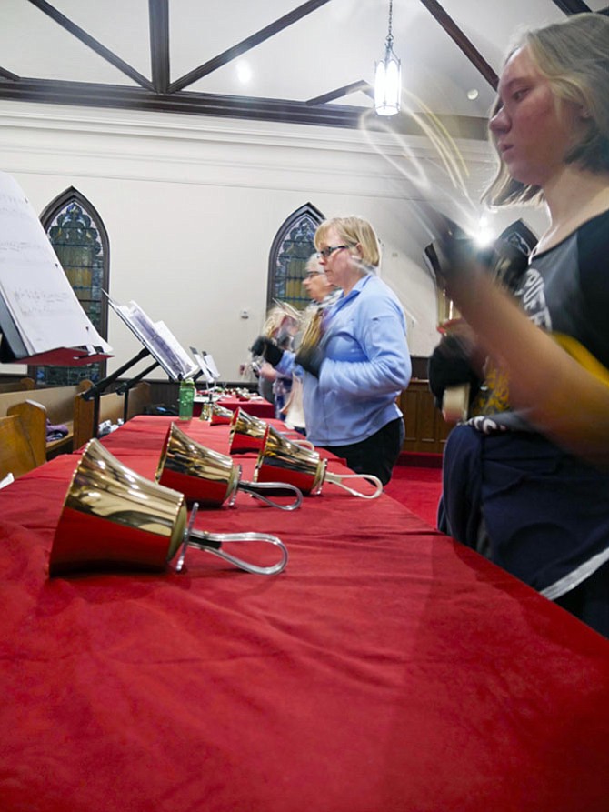 Julianne Lane is the youngest ringer at 14. Her motion blurs as she scoops her bell upward while she rings the largest and heaviest bell. She says she has been playing for about two years. Lane is responsible for the C, D and E bells.