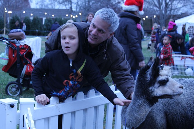 Freedom Hill Elementary School student Evan Fowler, 11, and his dad Geoff Fowler pet an alpaca at the petting zoo during the Celebration of Lights.
 
