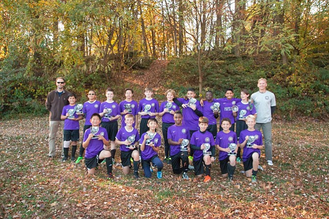 The Chantilly 1, Under 13 boys soccer team hold up their trophies at Draper Drive Park in Fairfax after winning their divisional championship game on Nov. 13. The team is led by Coach Eric Schuchard and Assistant Coach Nate Jencks. 