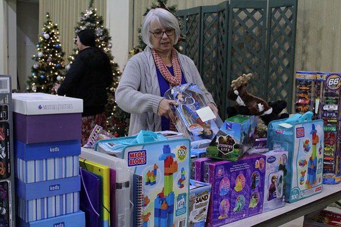 Eva Sereghy, a long-time Share volunteer and McLean Rotary member, sorts through a table of toys that was donated by one woman in the community.