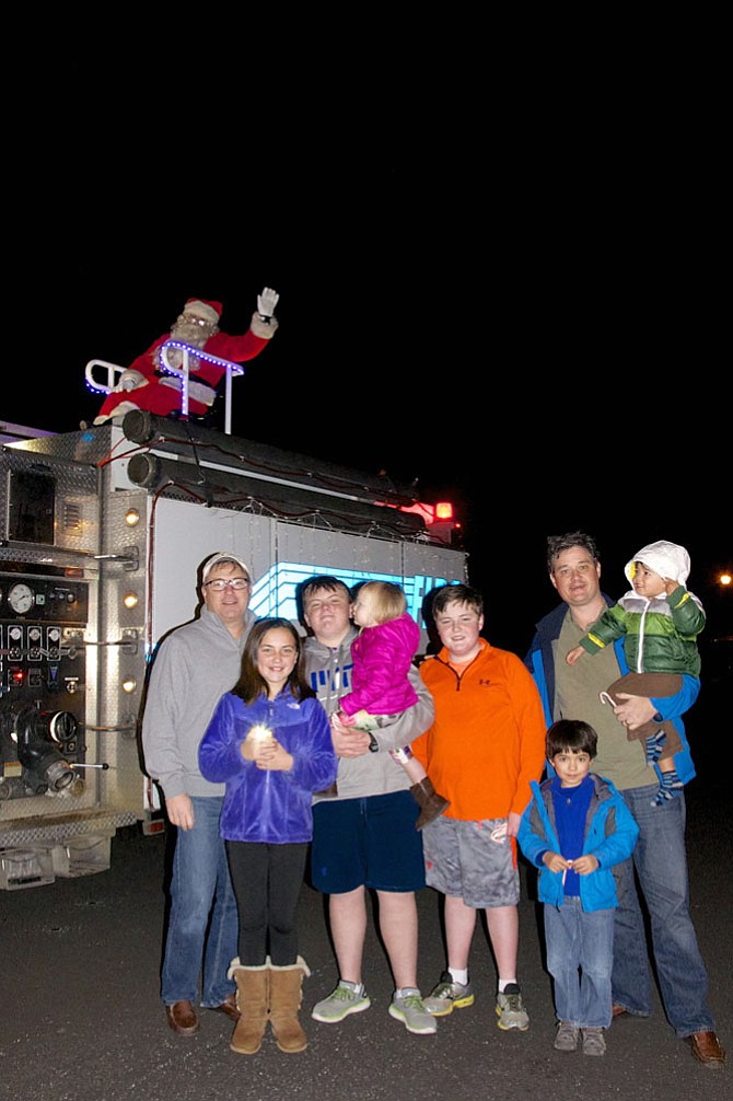 Santa is greeted by (from right): David Gwyn and his four children, Emily, Hayden, Payton, and Kipper; and Nick Farrel and his two sons, Thomas and Logan. 