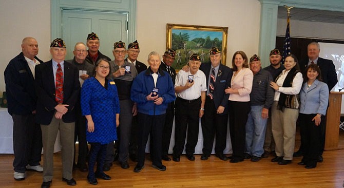 Veterans of World War II, Korea and Vietnam gather for a photo with dignitaries and guests of the Office of Historic Alexandria’s viewing event of the Virginia World War I and World War II Commemoration Commission Tribute to Veterans ceremony Dec. 8 at American Legion Post 24. The event was held commemorating the 75th anniversary of the U.S. entrance into WWII.