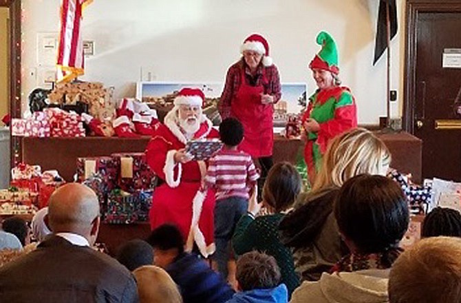 Santa Claus (Ralph Wallace) hands out gifts at a Christmas party hosted by the Old Dominion Boat Club Dec. 15  for children with special needs. More than 100 children from across the city attended the annual event.